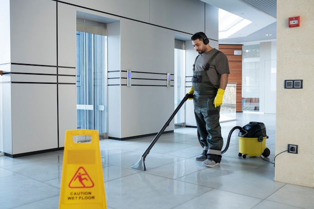 full-shot-man-vacuuming-floor_23-2149345547